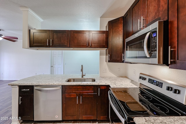 5401 E Van Buren St Unit 2095, Phoenix, AZ 85008 - kitchen with light stone counters, stainless steel appliances, a ceiling fan, dark brown cabinetry, and a sink