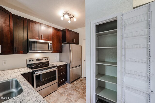 5401 E Van Buren St Unit 2095, Phoenix, AZ 85008 - kitchen featuring stainless steel appliances, light stone counters, and dark brown cabinetry