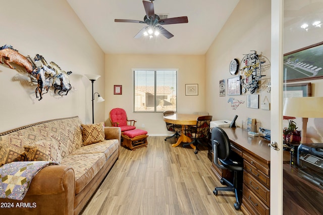 home office with vaulted ceiling, ceiling fan, and light hardwood / wood-style flooring