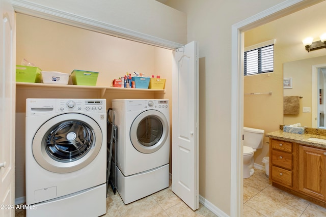 laundry area featuring sink, washing machine and clothes dryer, and light tile patterned floors