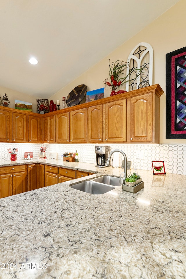 kitchen featuring lofted ceiling, sink, and decorative backsplash