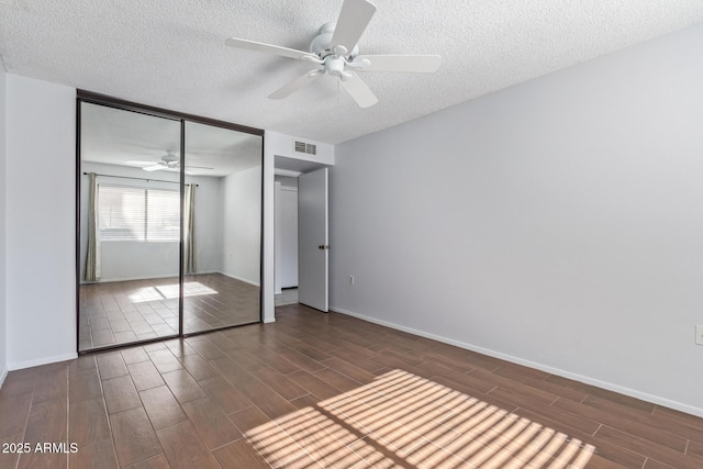 unfurnished bedroom with ceiling fan, a textured ceiling, and a closet