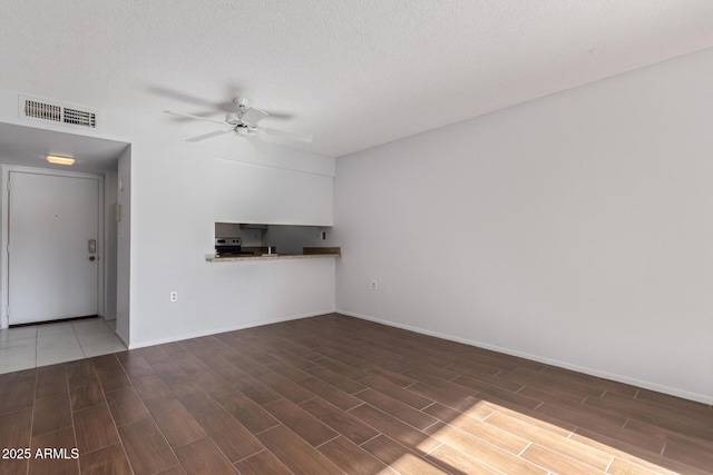 unfurnished living room with a textured ceiling and ceiling fan