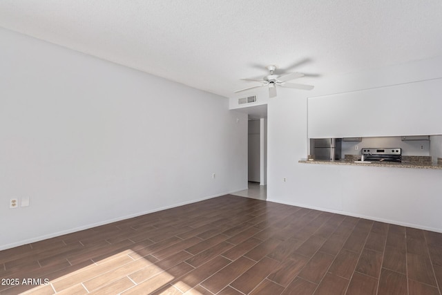 unfurnished living room featuring ceiling fan and a textured ceiling