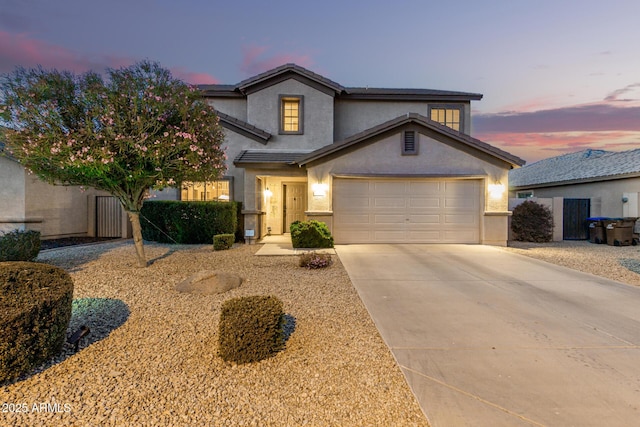 traditional-style home with a garage, driveway, and stucco siding