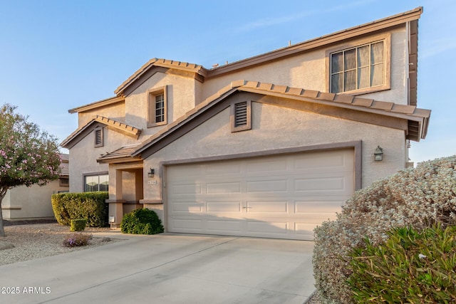 view of front of property with a garage, driveway, a tile roof, and stucco siding