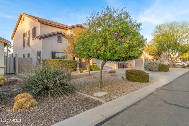 view of front of property with driveway, fence, and stucco siding