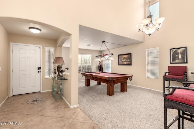 game room featuring light carpet, billiards, arched walkways, baseboards, and light tile patterned flooring