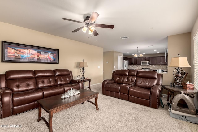 living room featuring recessed lighting, light colored carpet, visible vents, baseboards, and ceiling fan with notable chandelier