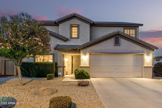 traditional-style home with concrete driveway, a tiled roof, and stucco siding