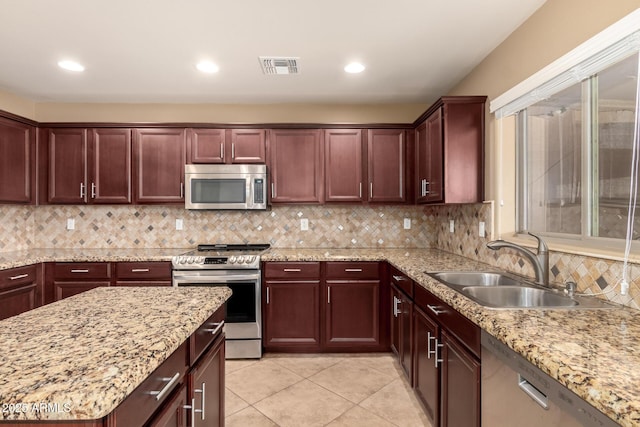 kitchen with stainless steel appliances, visible vents, backsplash, light tile patterned flooring, and a sink