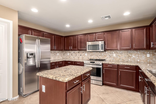 kitchen with tasteful backsplash, visible vents, a kitchen island, appliances with stainless steel finishes, and light tile patterned flooring