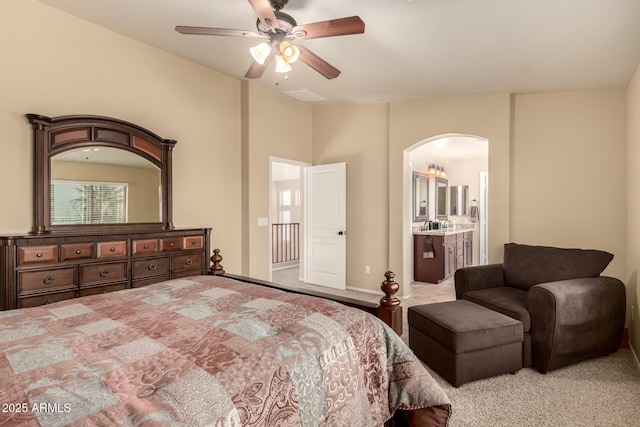 bedroom featuring visible vents, arched walkways, a ceiling fan, connected bathroom, and carpet