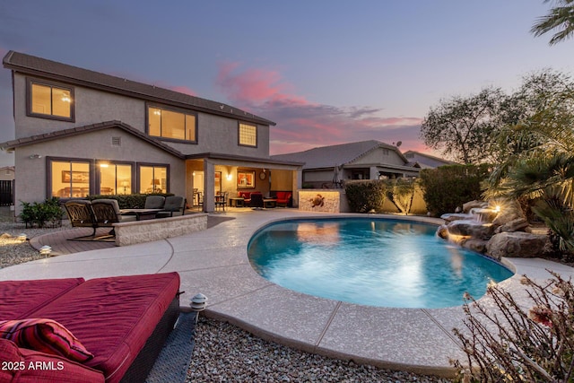 pool at dusk featuring a fenced in pool, a patio, and an outdoor living space