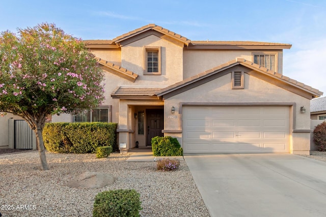 view of front of property with a garage, concrete driveway, a tile roof, and stucco siding