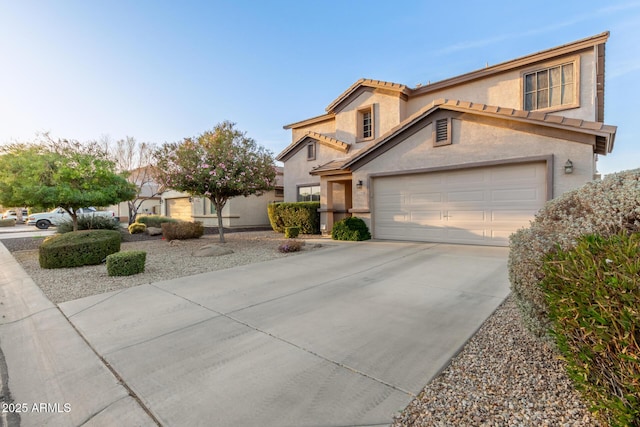 view of front of home with driveway, a tile roof, and stucco siding