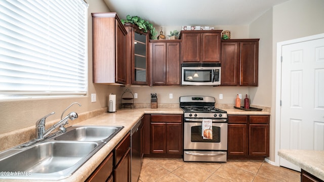 kitchen with stainless steel appliances, sink, and light tile patterned floors