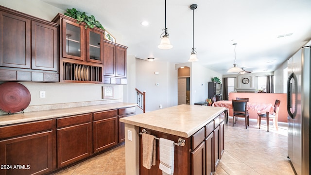 kitchen featuring a kitchen island, ceiling fan, decorative light fixtures, stainless steel refrigerator, and light tile patterned floors