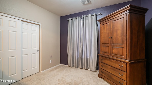 bedroom with a closet and light colored carpet