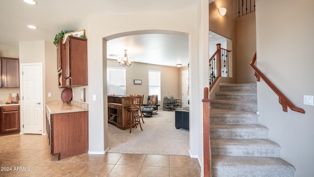 stairway featuring carpet floors and an inviting chandelier