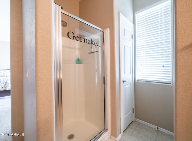 bathroom with a shower with shower door and tile patterned flooring