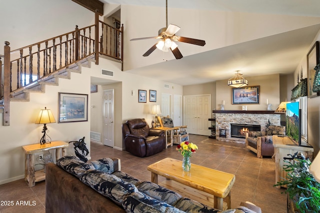 4002 N San Gabriel Cir, Mesa, AZ 85215 - living room with ceiling fan, tile patterned flooring, a high ceiling, a stone fireplace, and stairs