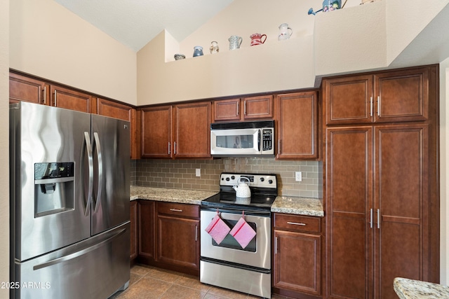 4002 N San Gabriel Cir, Mesa, AZ 85215 - kitchen featuring stainless steel appliances, decorative backsplash, light tile patterned floors, vaulted ceiling, and light stone countertops