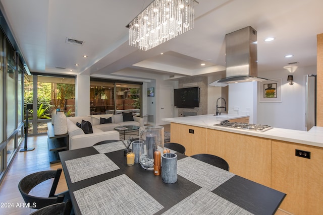 dining area with sink, light wood-type flooring, and a wall of windows