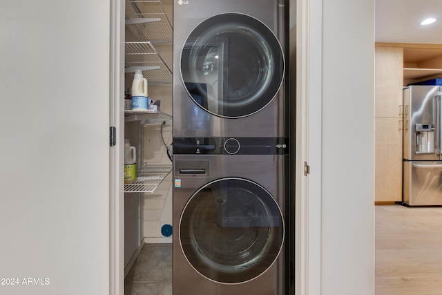 laundry area featuring light hardwood / wood-style floors and stacked washer / drying machine