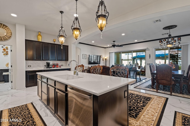 kitchen with tasteful backsplash, stainless steel dishwasher, sink, decorative light fixtures, and an island with sink