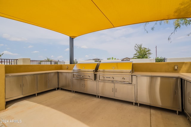 view of patio featuring an outdoor kitchen and a grill