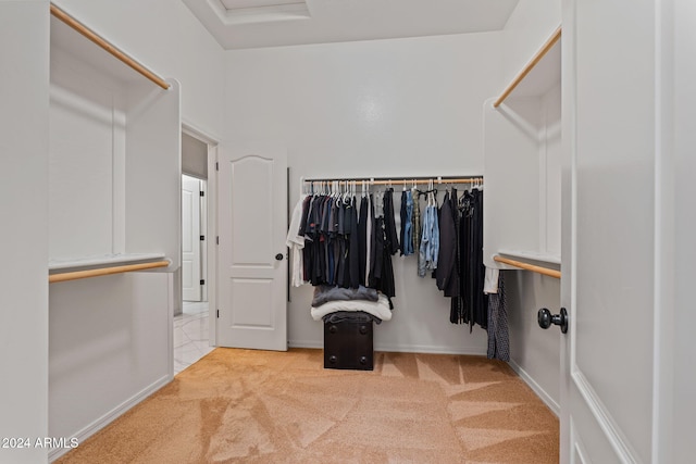 walk in closet featuring light colored carpet