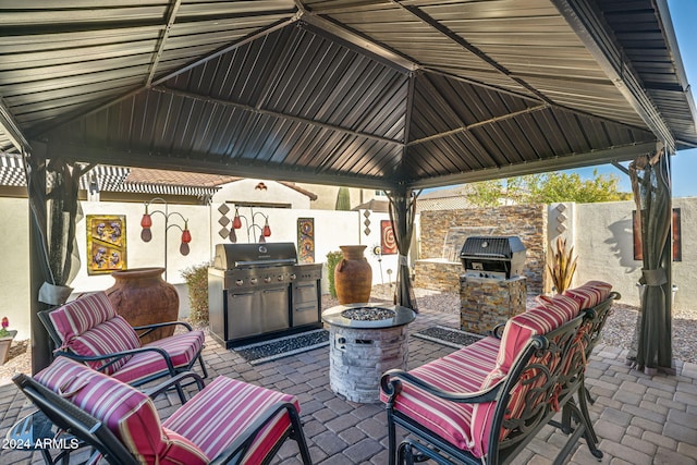 view of patio / terrace with a gazebo, a grill, exterior kitchen, and an outdoor fire pit