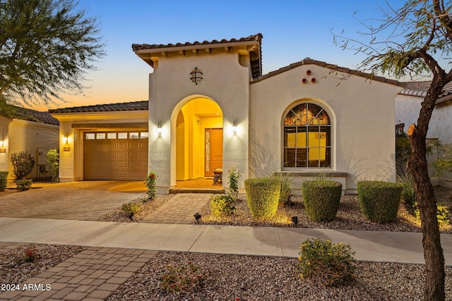 mediterranean / spanish home featuring a garage