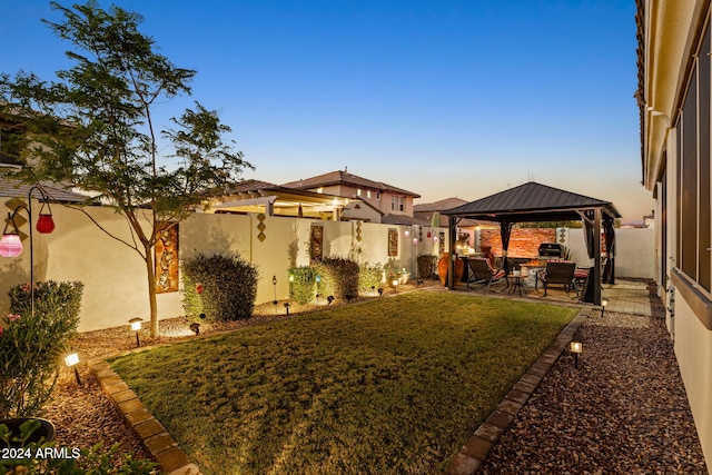 yard at dusk with a gazebo and a patio