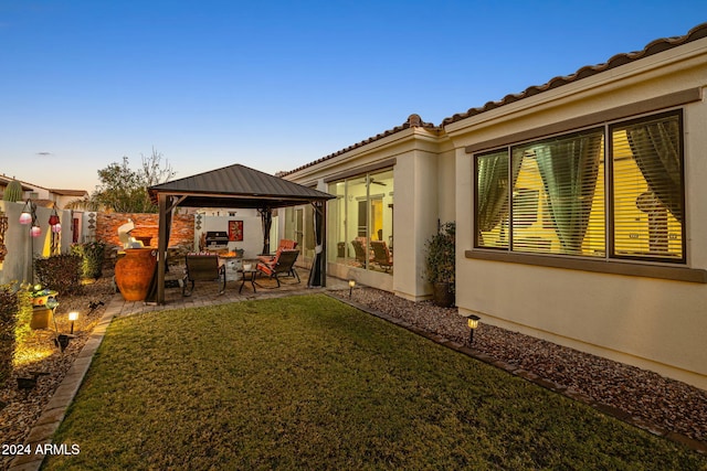 yard at dusk with a gazebo and a patio