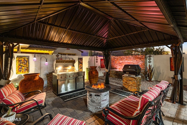 view of patio with a gazebo, area for grilling, and an outdoor living space with a fire pit