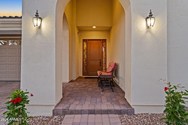 exterior entry at dusk featuring a garage