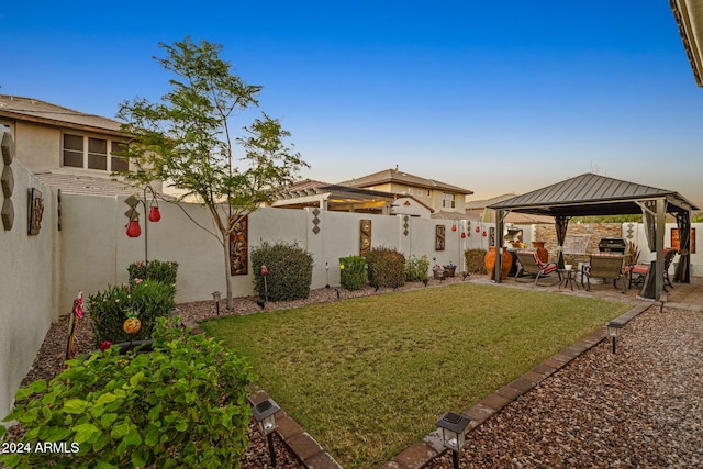 yard at dusk with a gazebo and a patio area