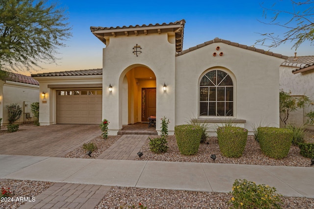 mediterranean / spanish-style home with a garage