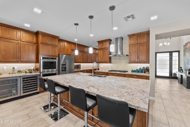 4093 Miners Gulch Way, Wickenburg, AZ 85390 - kitchen with visible vents, brown cabinets, wall chimney exhaust hood, appliances with stainless steel finishes, and a sink