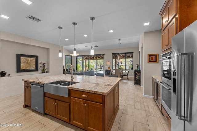 4093 Miners Gulch Way, Wickenburg, AZ 85390 - kitchen featuring a sink, visible vents, stainless steel appliances, and brown cabinetry