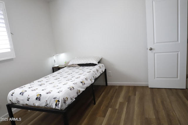 bedroom with dark hardwood / wood-style flooring