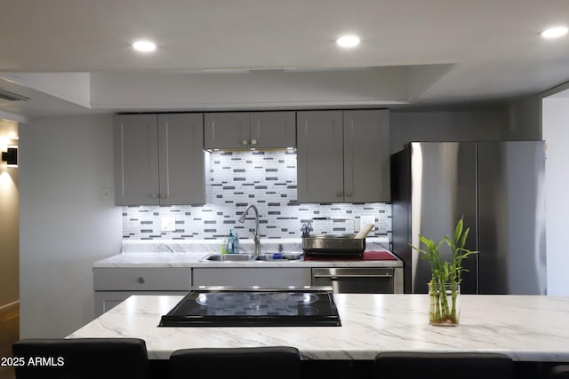 kitchen with decorative backsplash, appliances with stainless steel finishes, gray cabinetry, and sink