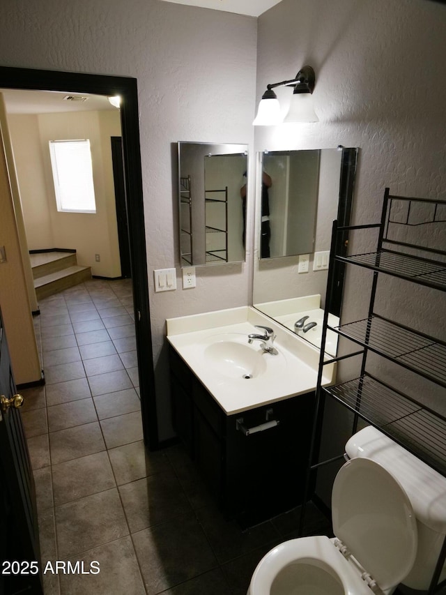 43241 W Kristal Ln, Maricopa, AZ 85138 - bathroom with a textured wall, vanity, tile patterned floors, and toilet