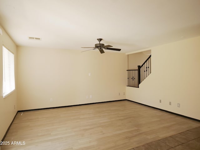 43241 W Kristal Ln, Maricopa, AZ 85138 - unfurnished room with a ceiling fan, stairway, light wood-style floors, and baseboards