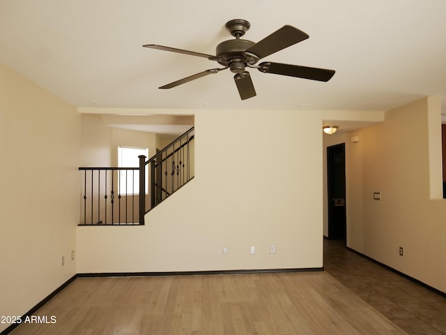 43241 W Kristal Ln, Maricopa, AZ 85138 - spare room featuring wood finished floors, baseboards, ceiling fan, and stairs
