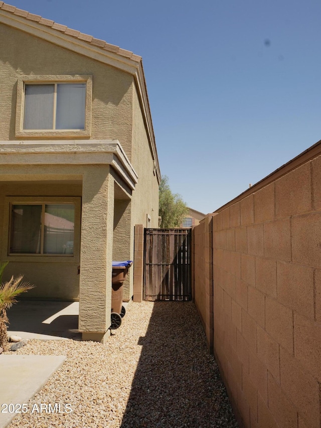 43241 W Kristal Ln, Maricopa, AZ 85138 - view of property exterior featuring stucco siding and a gate