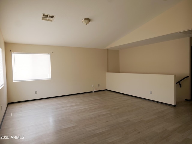 43241 W Kristal Ln, Maricopa, AZ 85138 - spare room featuring light wood-type flooring, baseboards, and lofted ceiling