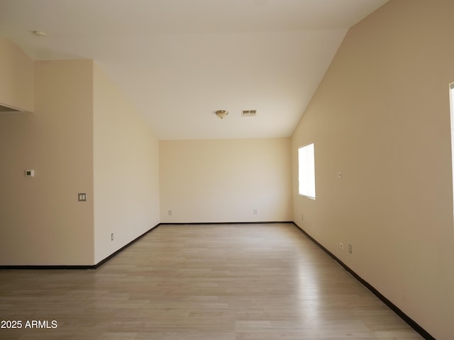 43241 W Kristal Ln, Maricopa, AZ 85138 - spare room with light wood-style floors, baseboards, and lofted ceiling